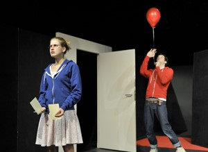 Schauspieler auf der Bühne mit rotem Luftballon